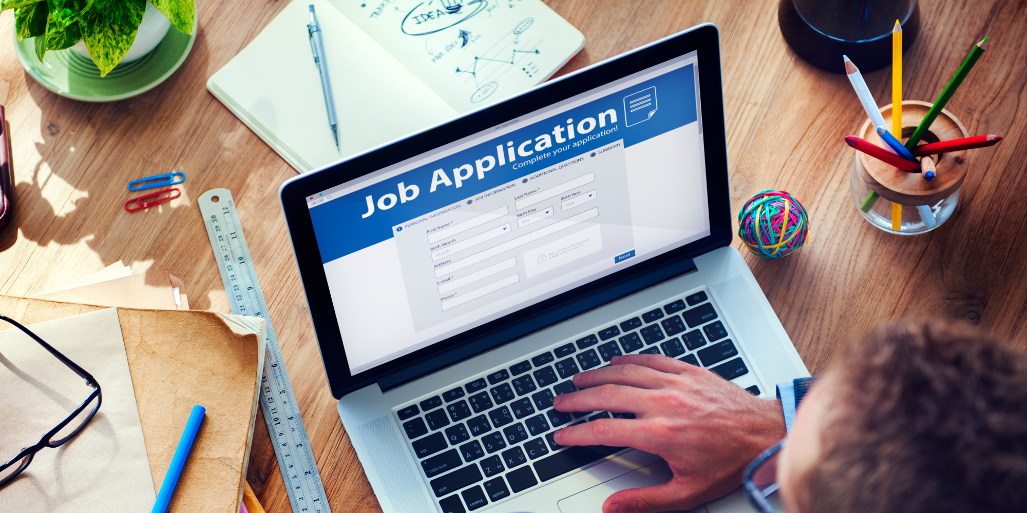 Job applicant filling out job application on laptop 