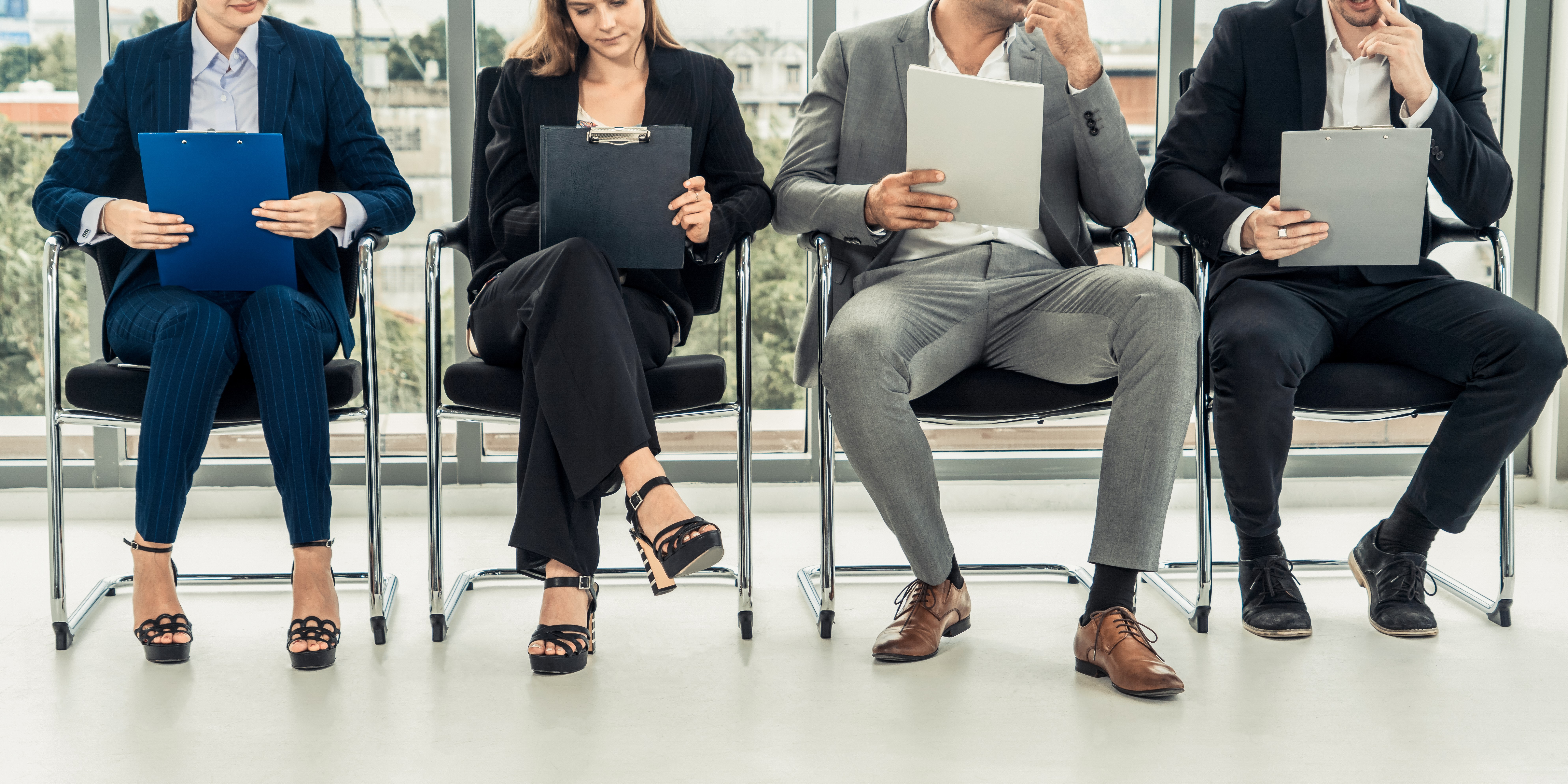 Job applicants holding resume CV folder while waiting for job interview
